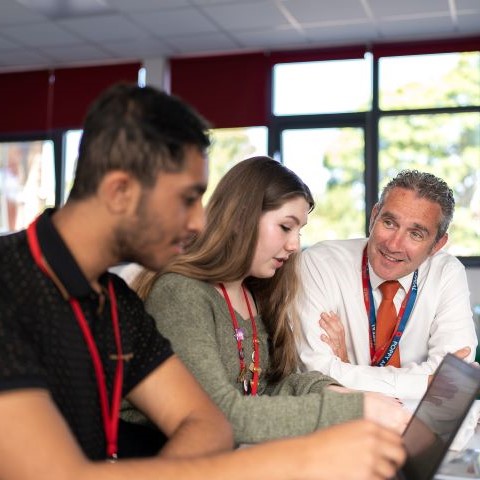 Adviser with two students sitting at a desk