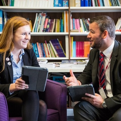 Adviser and student chatting in library