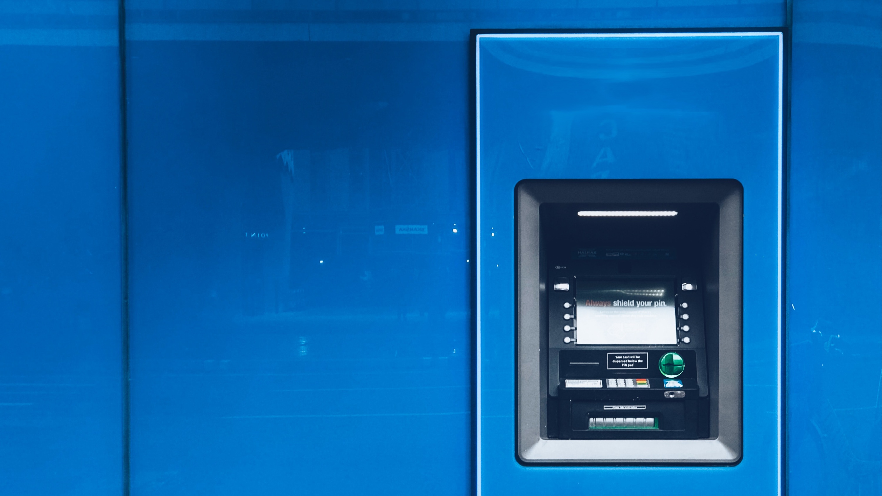an ATM cash machine set into a blue plastic wall