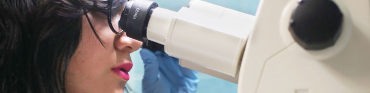 Female intern looking into a microscope