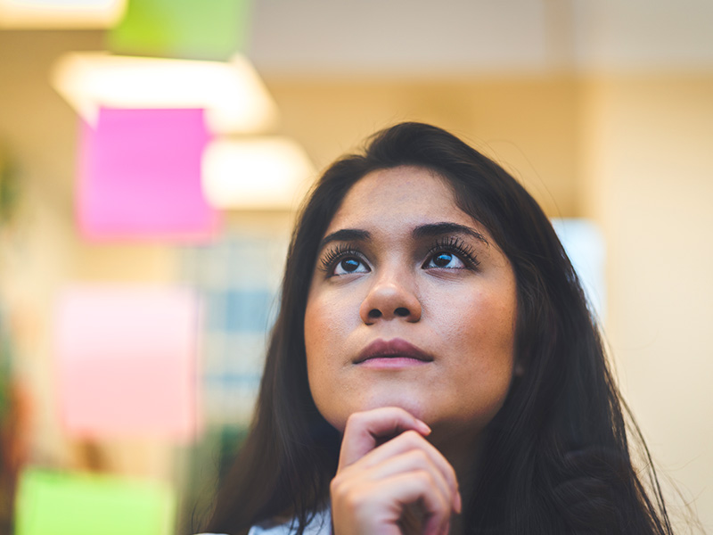 Woman looking at her options on post it notes
