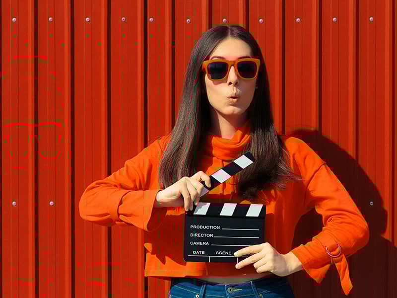 Young woman holding a clapper board at an audition