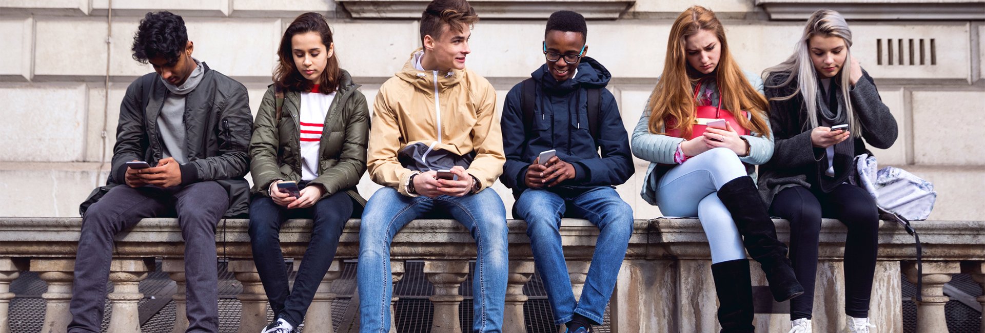 Students sitting on wall 
