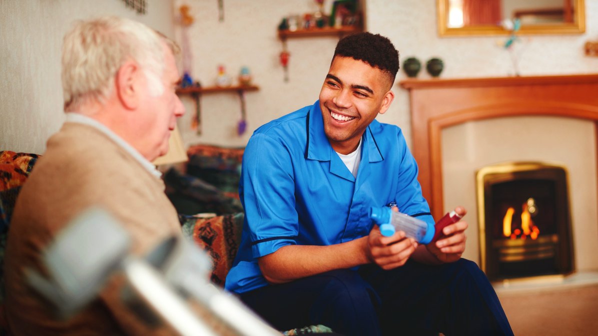 An apprentice nurse talks with an elderly patient