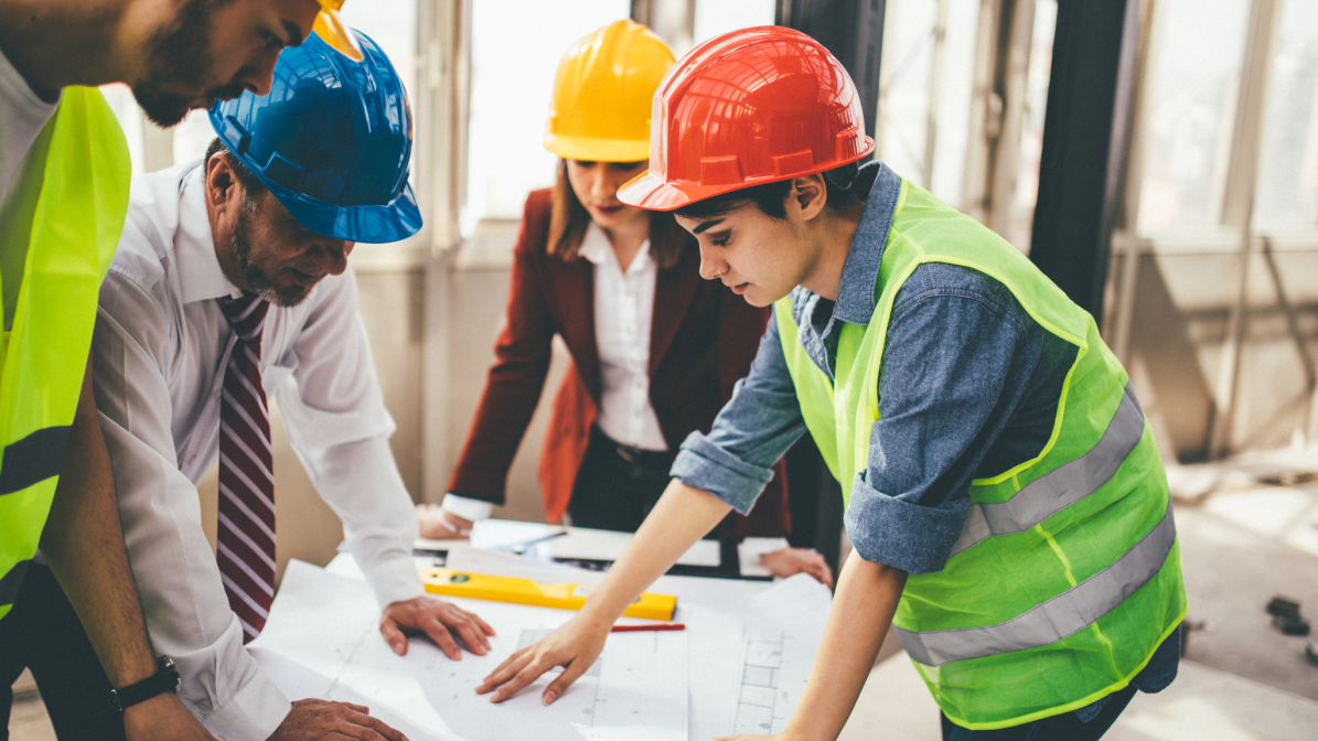 Industry_Marketing_Construction_Article_Image_Box_2_260324 Four construction workers looking at blueprints on a construction site