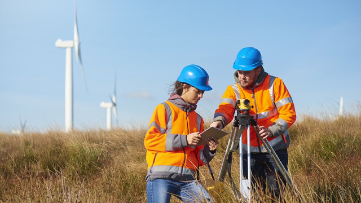 Two quantity surveyors working in a field