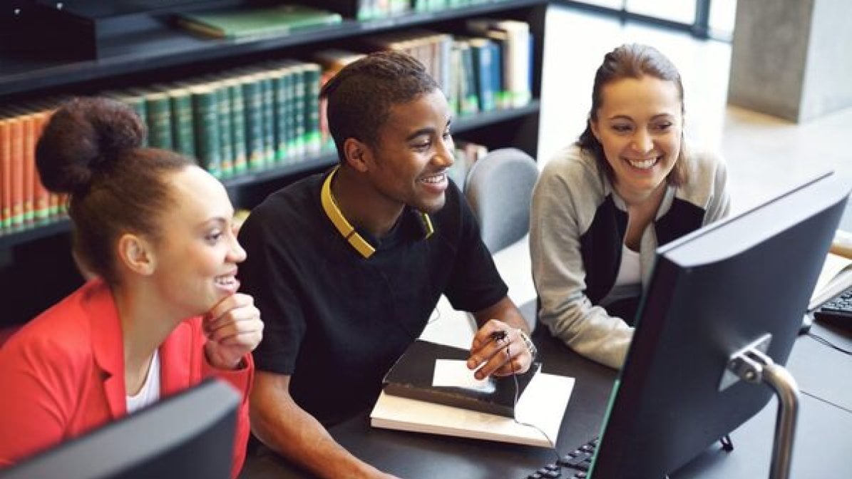 Students researching universities on a PC 