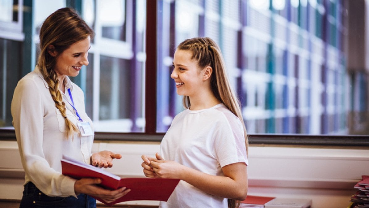 Teacher talking with student in school