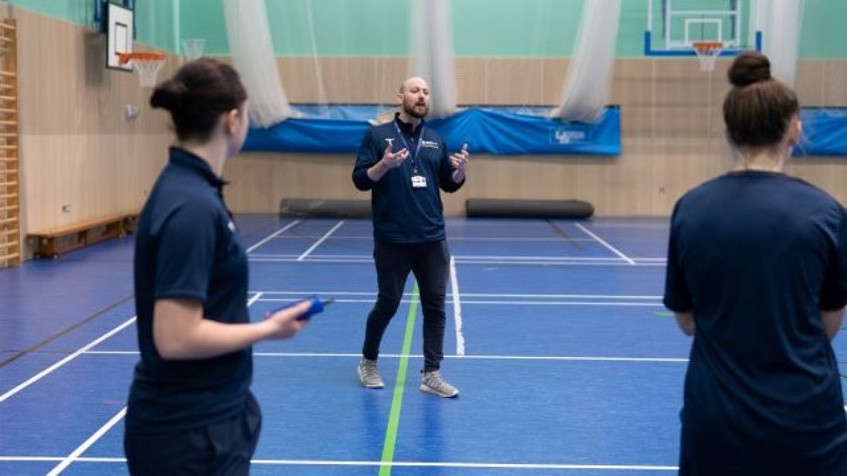 Students playing team sports in a sports hall