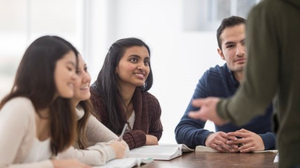 Religion and theology students discussing a book