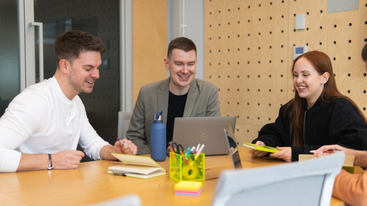 Apprentices sitting around a table in meeting