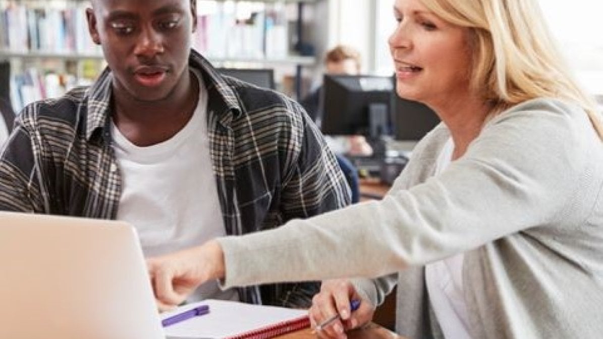 Adviser with student in library