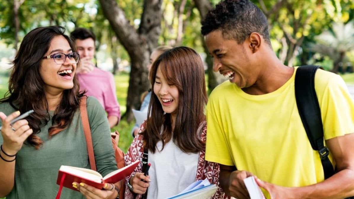 Laughing students walking in park