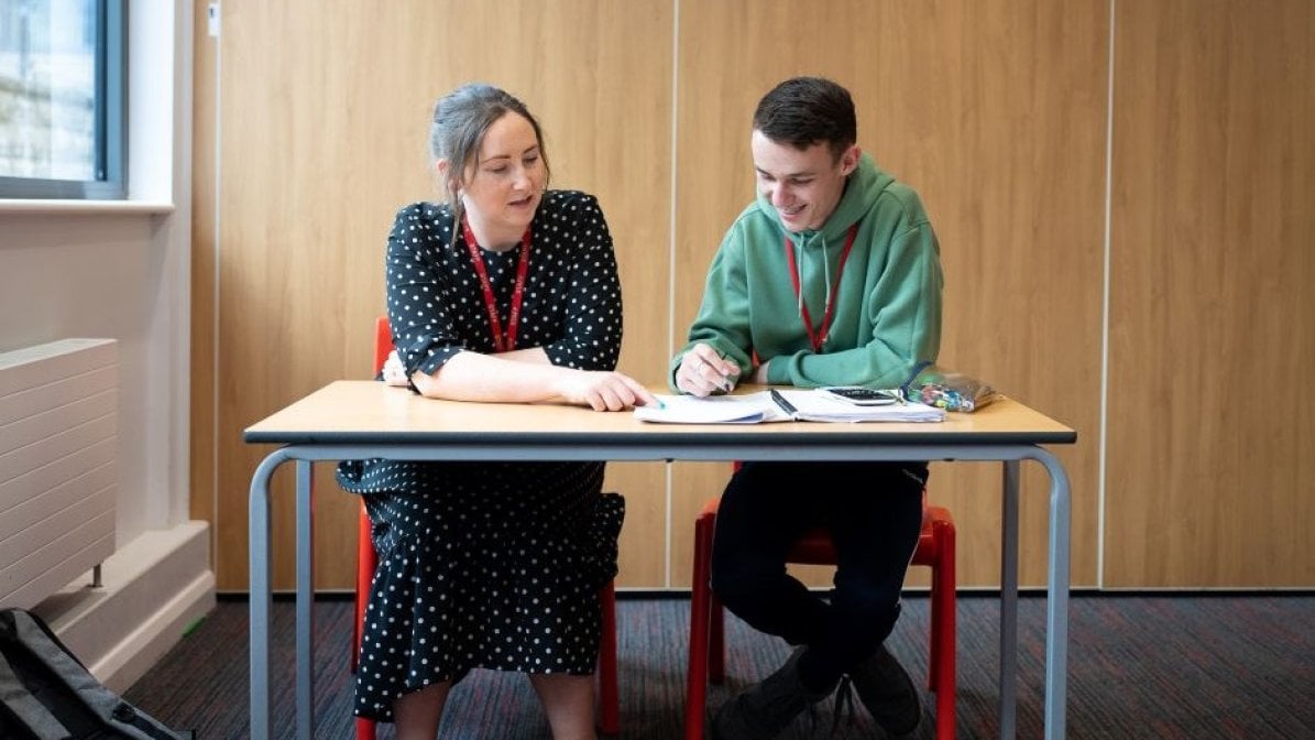 Adviser chatting to student in classroom