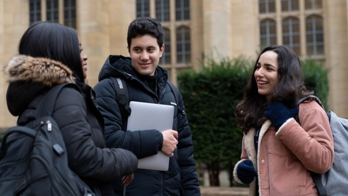 Students chatting outside campus building 