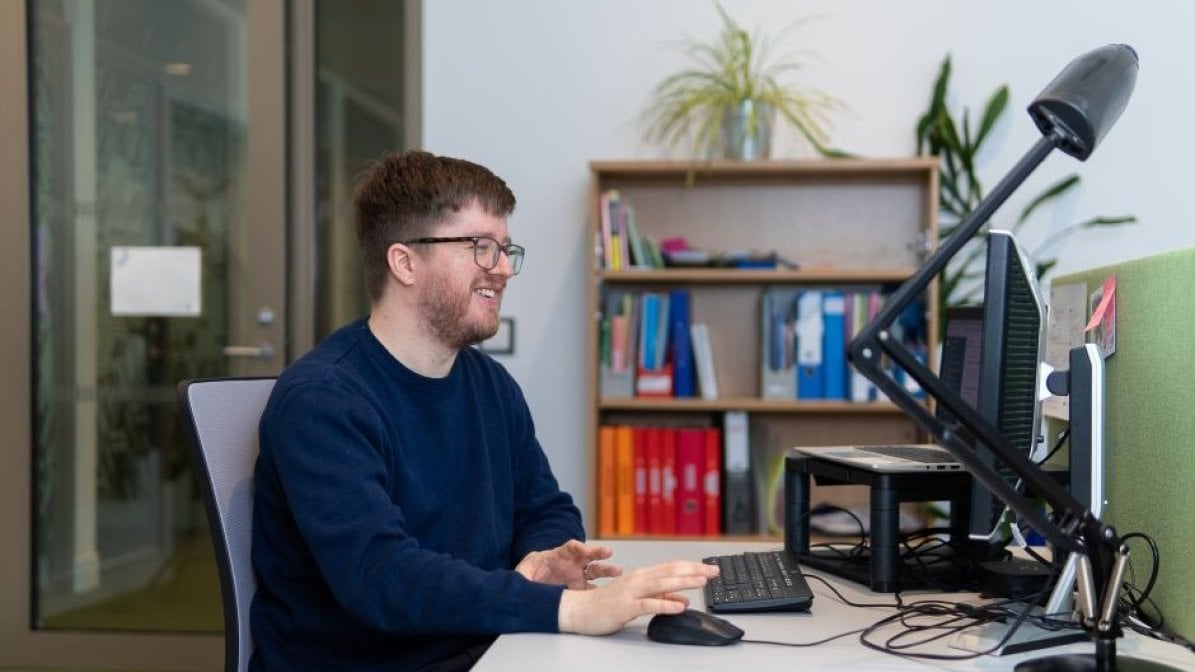 Adviser sitting at desk working on computer 