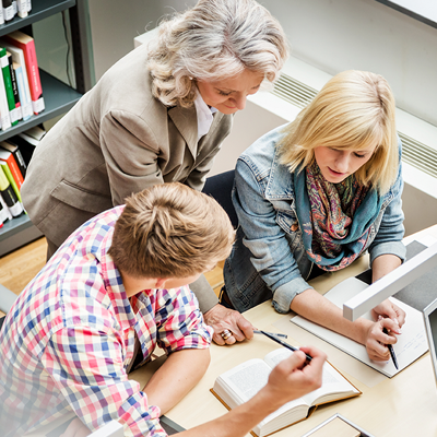 Adviser talking to students at a desk
