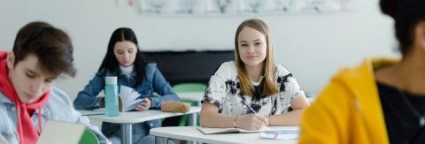 Clearing students sitting at desks in classroom