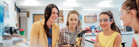 A teacher sat in a science laboratory with a group of 3 students