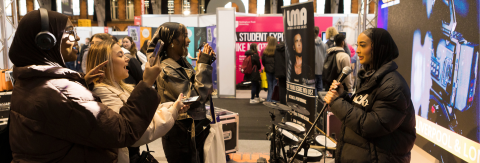 Students engaging with an exhibitor at a UCAS event.