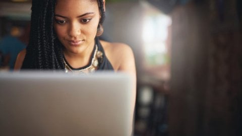 A girl sits at her laptop