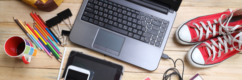 Laptop, stationery and trainers on the floor