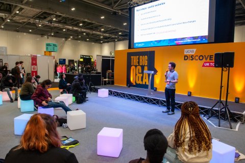 Event space with speaker and students on stools