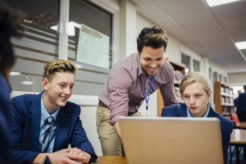 Teacher and students using laptop  