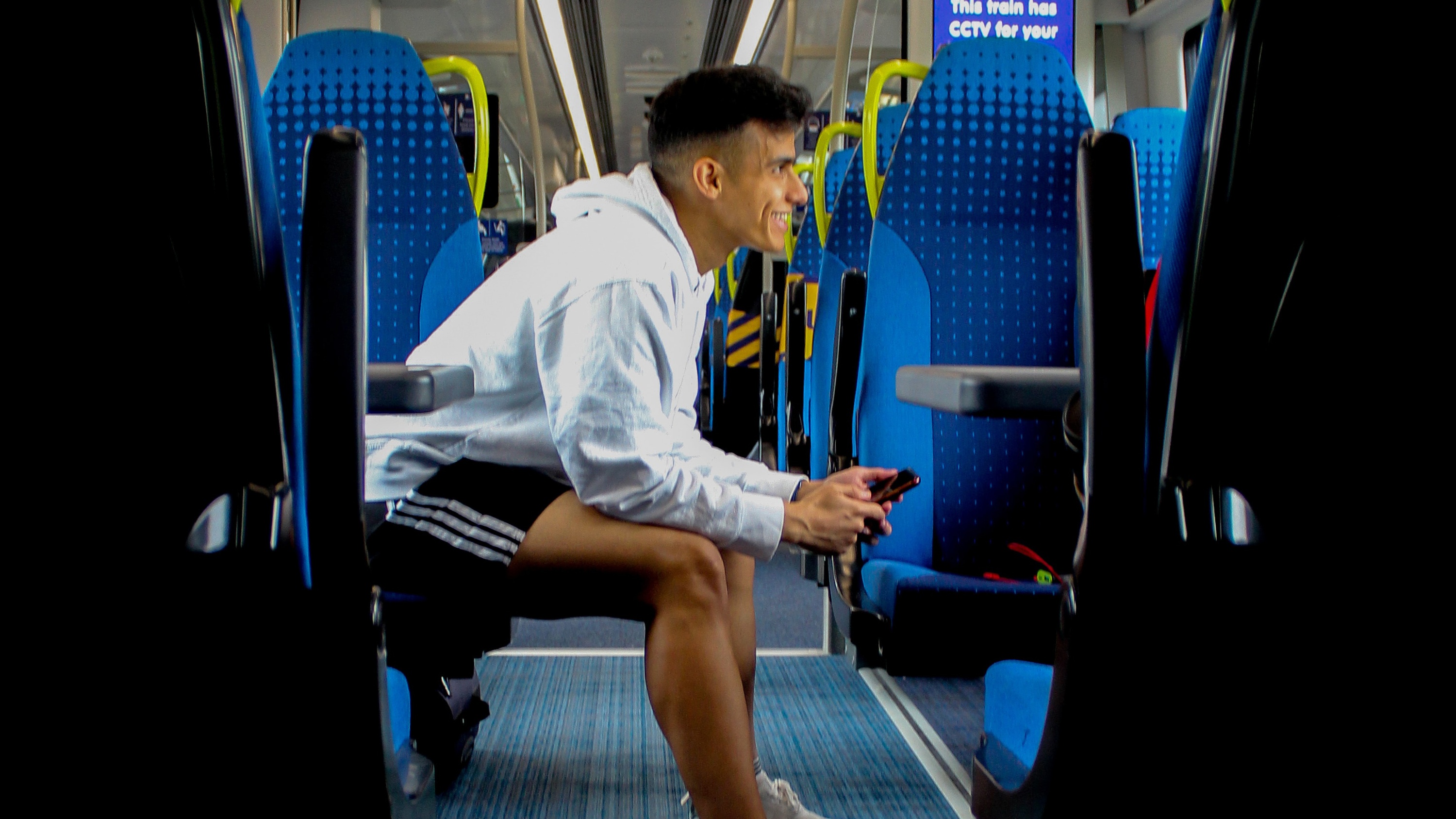 A young man sits on a train